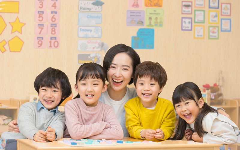 Kindergarten teacher playing with children
